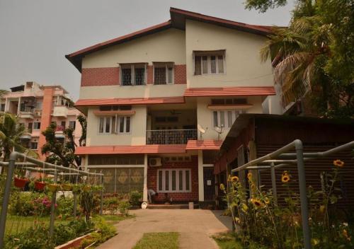 ein großes weißes Haus mit einem Garten davor in der Unterkunft Harmony-Ka Villa in Guwahati