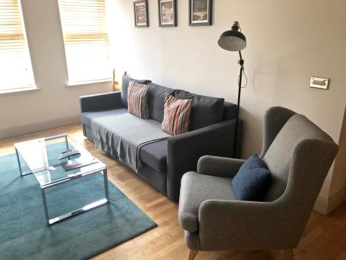 a living room with a couch and a chair at Pelican House is an exclusive contemporary development in Newbury