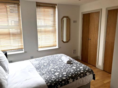 a bedroom with a bed with a black and white blanket at Pelican House is an exclusive contemporary development in Newbury