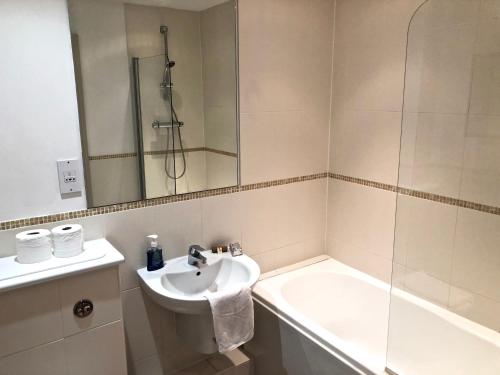 y baño con lavabo, ducha y bañera. en Pelican House is an exclusive contemporary development, en Newbury