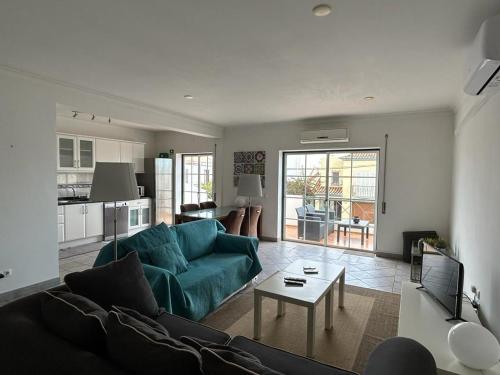 a living room with a blue couch and a table at Tavira near the center - two bedroom with balcony in Tavira