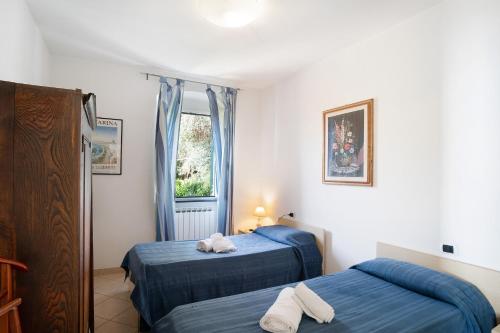 a bedroom with two beds and a window at Sardegnoli, borgo dei pescatori in Cervo