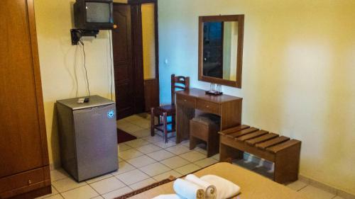 a room with a bathroom with a table and a television at Pineas in Kalabaka
