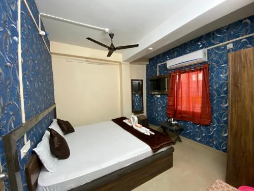 1 dormitorio con cama y pared azul en Sea Pearl Homestay, en Port Blair