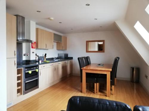 uma cozinha com mesa e cadeiras num quarto em Pelican House is an exclusive contemporary development em Newbury