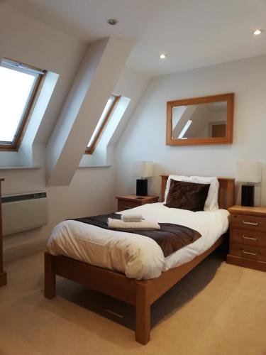 um quarto com uma cama num sótão com clarabóias em Pelican House is an exclusive contemporary development em Newbury