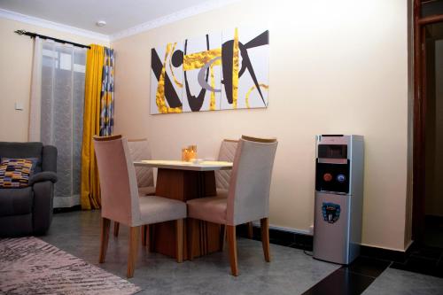uma sala de jantar com uma mesa e cadeiras e um frigorífico em The Haven254 em Nakuru