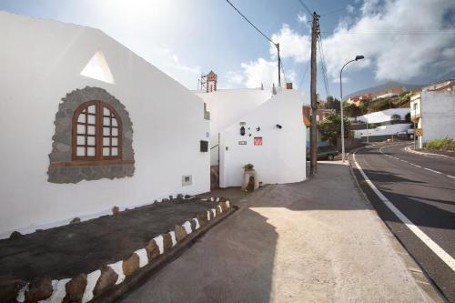a white building with a window on the side of a street at los diablitos 4 in San Juan de la Rambla