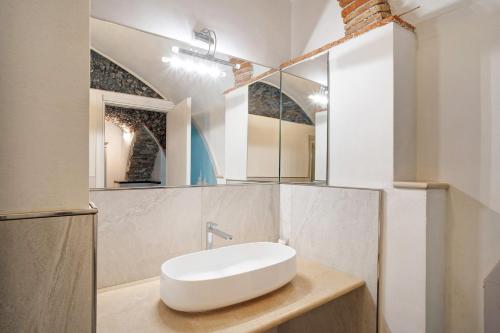 uma casa de banho com um lavatório branco e um espelho. em Dipinti, borgo dei pescatori em Cervo