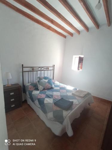 a bedroom with a bed with a quilt on it at Cortijocueva con encanto natural in Terque