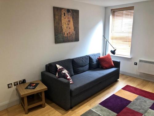 ein Wohnzimmer mit einem blauen Sofa und einem Tisch in der Unterkunft Pelican House is an exclusive contemporary development in Newbury