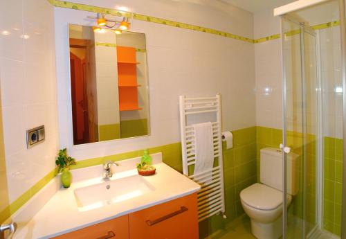een badkamer met een wastafel, een toilet en een spiegel bij Casa rural Navarra cerca del nacedero del Urederra Belastegui in Eulz