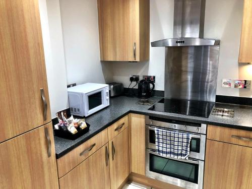 a kitchen with a microwave oven and a stove at Pelican House is an exclusive contemporary development in Newbury