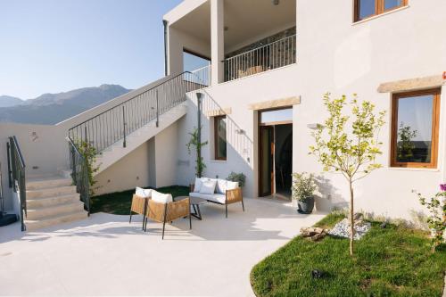 a patio of a house with a table and chairs at Mirthea Suites in Mírthios