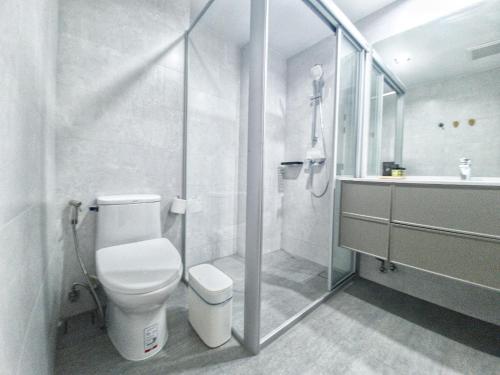 uma casa de banho com um WC, um chuveiro e um lavatório. em Tassanaplace Boutique Hotel (ฺBansuan) em Chon Buri