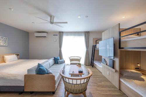 Tsuboya的住宿－アルファベットイン那覇国際通りWEST，一间卧室配有一张床、一张沙发和一张桌子