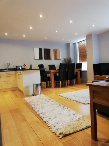 a kitchen and dining room with a table and chairs at Pelican House is an exclusive contemporary development in Newbury