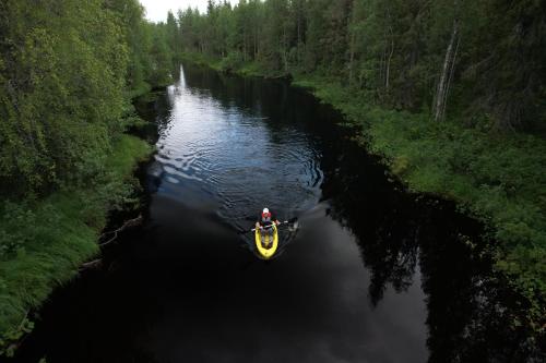 una persona en un barco amarillo en un río en In Love with Lapland Cabin en Ranua