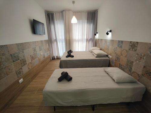 a bedroom with two beds and a teddy bear sitting on one of them at РUEВLO МAR, hotel-apartamento in Calpe
