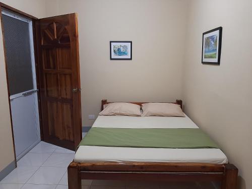 a small bed in a room with a door at Alimpay Foresters Apartment in Panglao