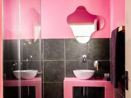 a bathroom with two sinks and a pink wall at Die Opstal house with Apartments in Paternoster