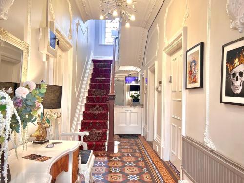 un pasillo con una escalera con una escalera roja en St Andrews house Hotel, en Preston