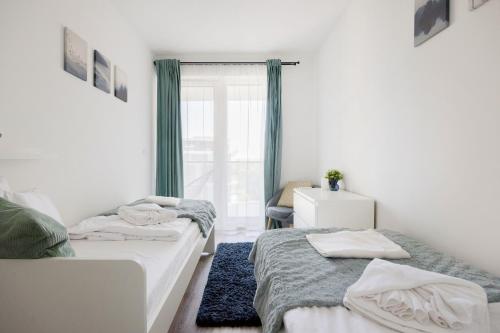 1 dormitorio con 2 camas y ventana en Modern Riverfront Apartment with Free Parking en Budapest