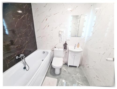 een badkamer met toilet, bad en wastafel bij SouvenirAppart Sienkiewicza in Bydgoszcz