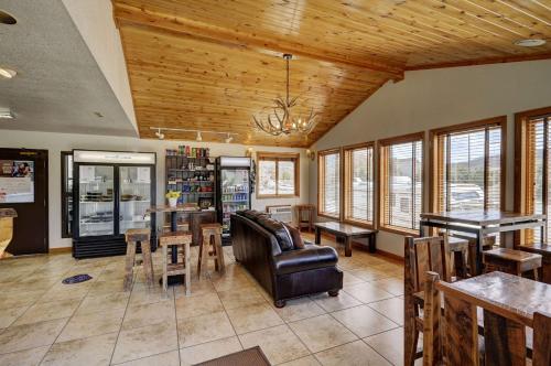 un soggiorno con divano, tavoli e finestre di Super 8 by Wyndham Gardiner/Yellowstone Park Area a Gardiner