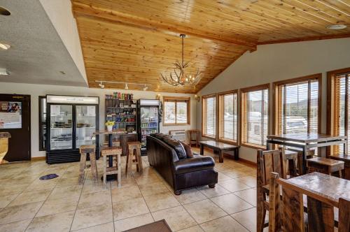 a living room with a couch and tables and windows at Super 8 by Wyndham Gardiner/Yellowstone Park Area in Gardiner