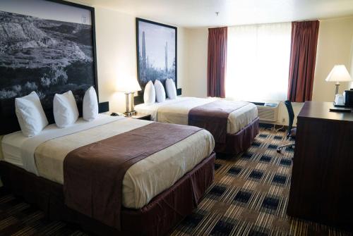 a hotel room with two beds and a desk at Super 8 by Wyndham Yuma in Yuma