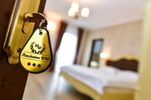 a tag on a door in a room with a bed at Pensiunea WW in Focşani