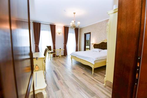 a bedroom with a bed and a table and chairs at Pensiunea WW in Focşani