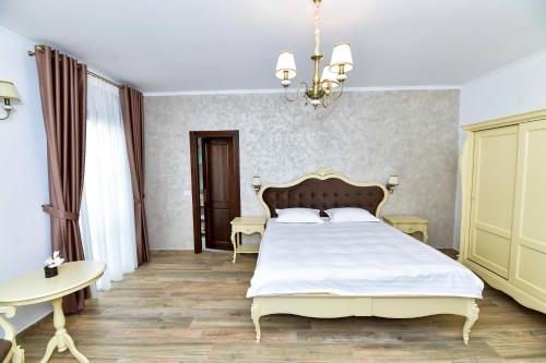 a bedroom with a large bed and a chandelier at Pensiunea WW in Focşani