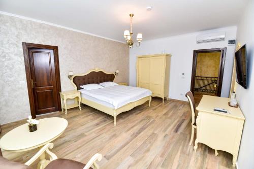 a bedroom with a bed and a table and chairs at Pensiunea WW in Focşani