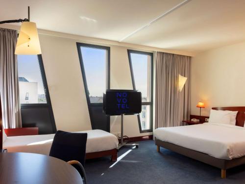 um quarto de hotel com duas camas e uma televisão de ecrã plano em Novotel Suites Marseille Centre Euromed em Marselha