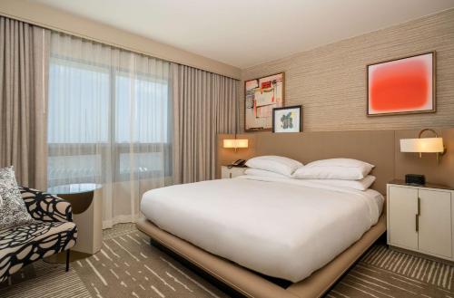 a bedroom with a large white bed and a window at Hilton San Diego Gaslamp Quarter in San Diego