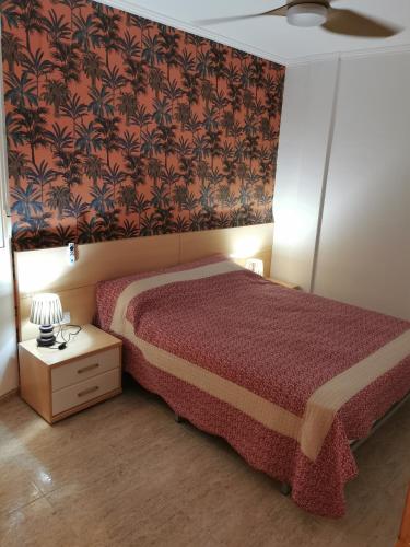 a bedroom with a bed with a red bedspread at Benicarlo Puerto in Benicarló