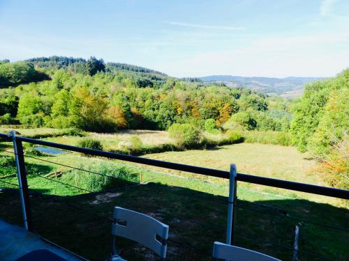 a balcony with a view of a field and trees at La Boucle des Molliers in Cenves