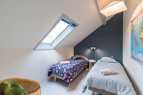 Schlafzimmer im Dachgeschoss mit 2 Betten und einem Fenster in der Unterkunft Appartement d'exception - proche de la mer in Saint-Brieuc