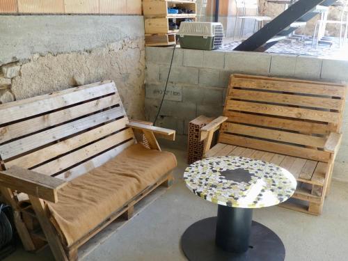 a bench and a table in a room at La Boucle des Molliers in Cenves