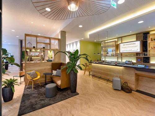 un restaurant avec une plante en pot dans une pièce dans l'établissement ibis Styles Aschaffenburg, à Aschaffenbourg