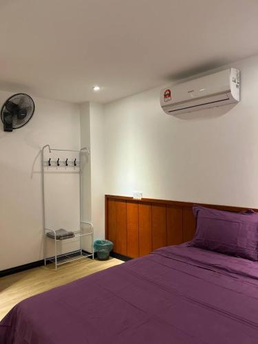 拿篤的住宿－The Garden House Lahad Datu，一间卧室配有一张带紫色棉被的床