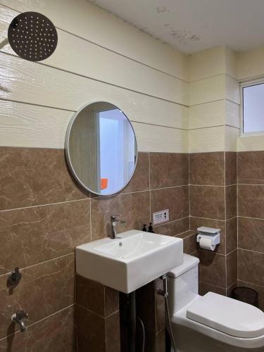 a bathroom with a sink and a mirror and a toilet at The Garden House Lahad Datu in Lahad Datu