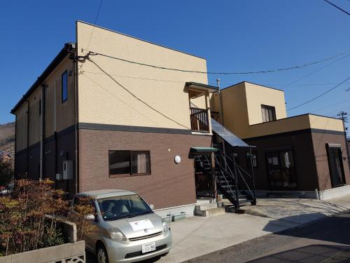 a small car parked in front of a building at Midori Guesthouse&Hostel in Tsushima
