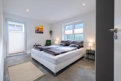 a large white bedroom with a large bed and two windows at Haus Paul in Kals am Großglockner