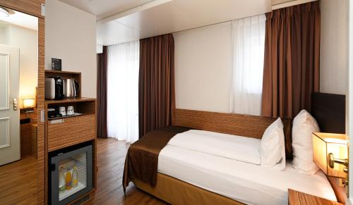 a hotel room with a bed and a television at Hotel Stoller in Zürich