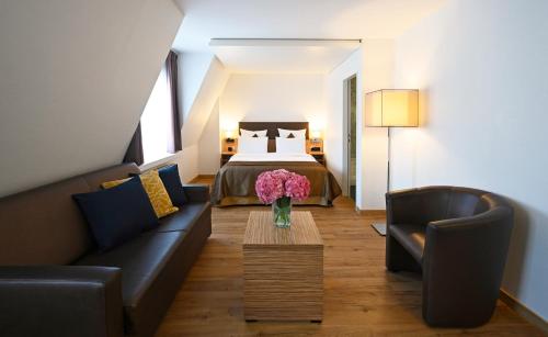 a living room with a bed and a couch and a table at Hotel Stoller in Zurich