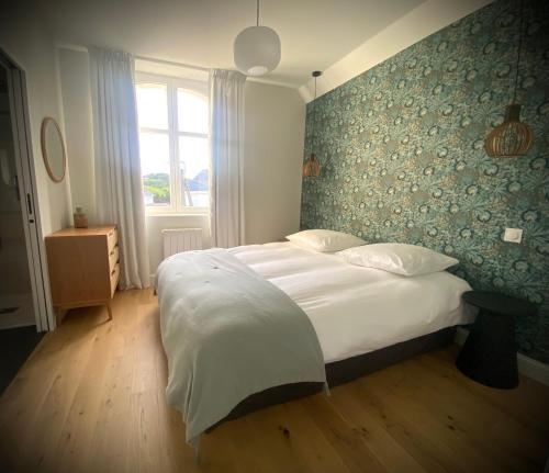 une chambre avec un grand lit blanc et une fenêtre dans l'établissement Centre de Pornichet à 300m de la plage, à Pornichet