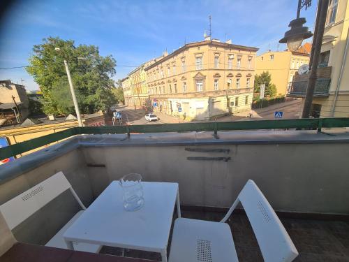 Biały stół i 2 krzesła na balkonie w obiekcie SouvenirAppart Sienkiewicza w Bydgoszczy